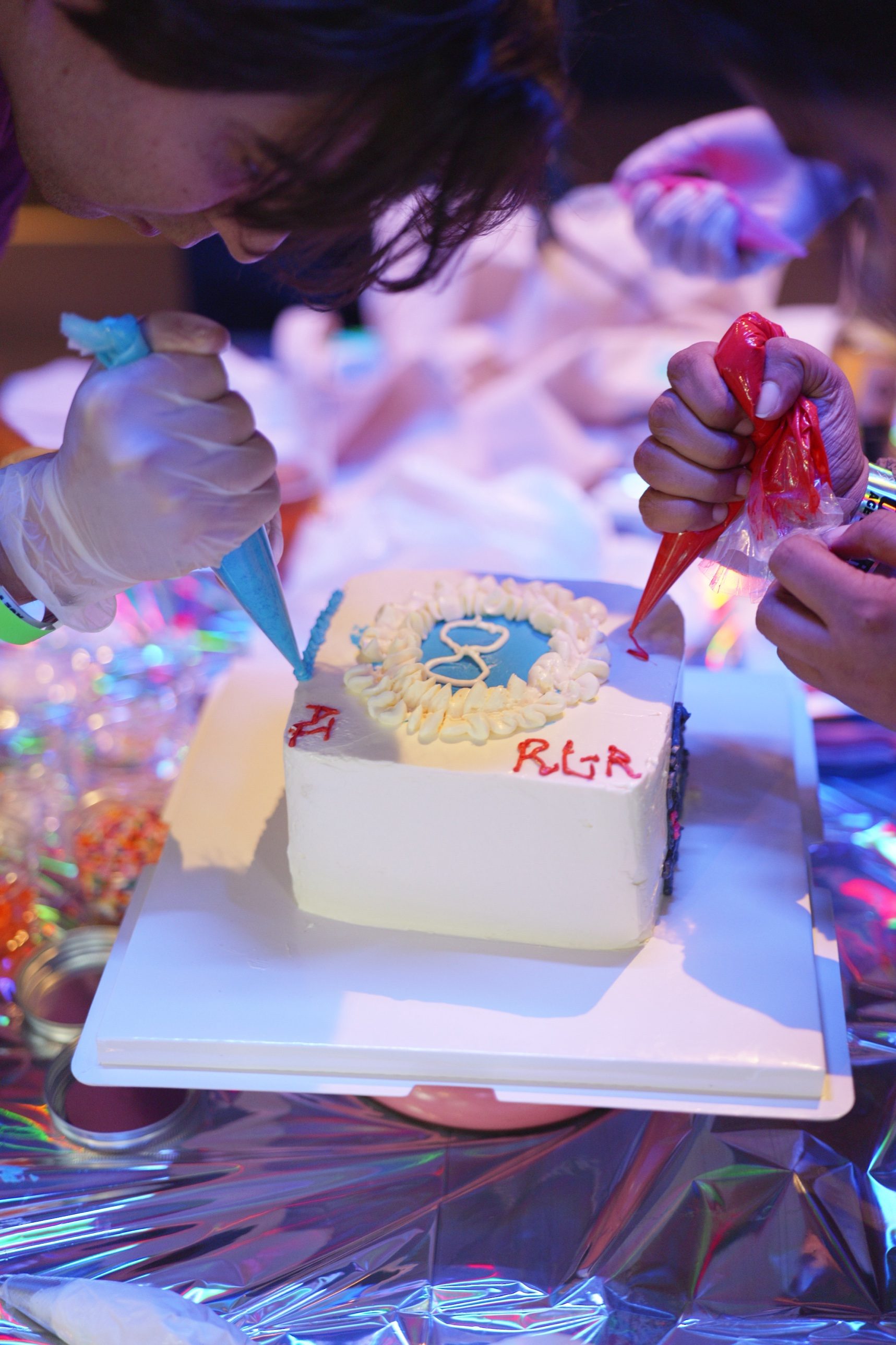 A guest piping icing onto a cake during a HoneyMe DIY cake decorating workshop