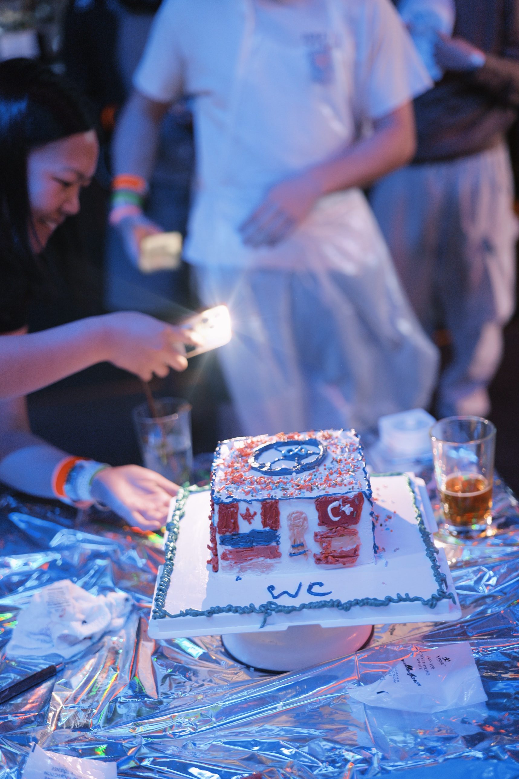 Lighting a candle on a custom decorated cake at a HoneyMe DIY workshop party